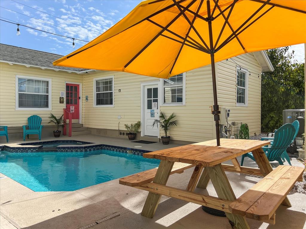 A yellow house with a swimming pool, patio, and picnic table under a yellow umbrella — 3801 1ST AVENUE S, ST PETERSBURG, FL
