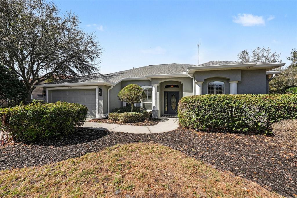 A single-story house with a gray exterior, a two-car garage, and a landscaped front yard — 12251 CREEK EDGE DRIVE, RIVERVIEW, FL