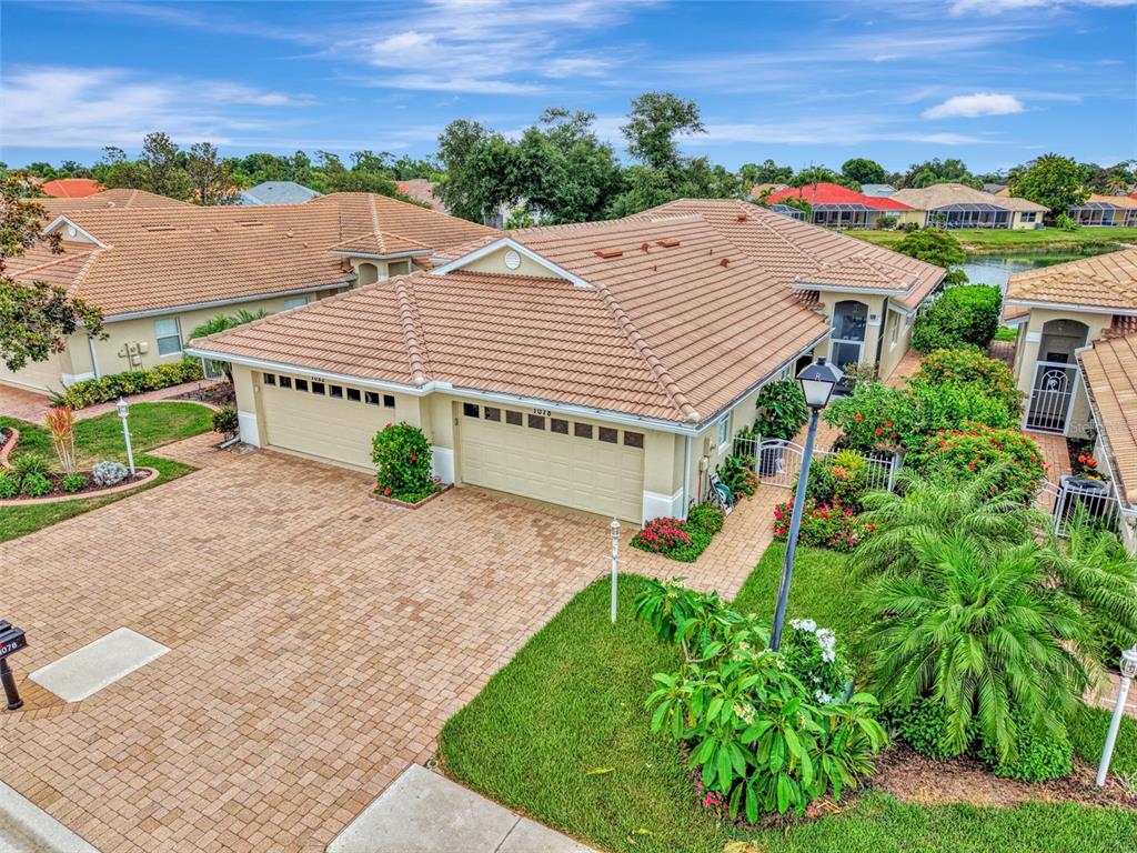 An aerial view of a tan house with a tiled roof and a brick driveway — 1078 TOPELIS DRIVE, ENGLEWOOD, FL