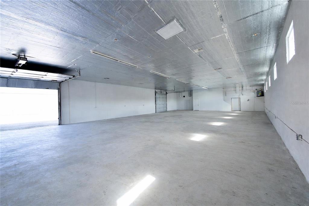 A large, empty warehouse space features a concrete floor and a metallic ceiling — 6010 WALL STREET, PORT RICHEY, FL