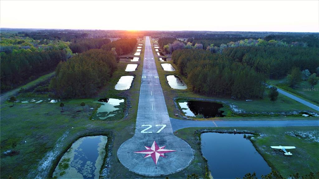 An aerial view shows a paved airport runway marked 27 with a compass rose design — Parcel 1 CR-18A, WORTHINGTON SPRINGS, FL