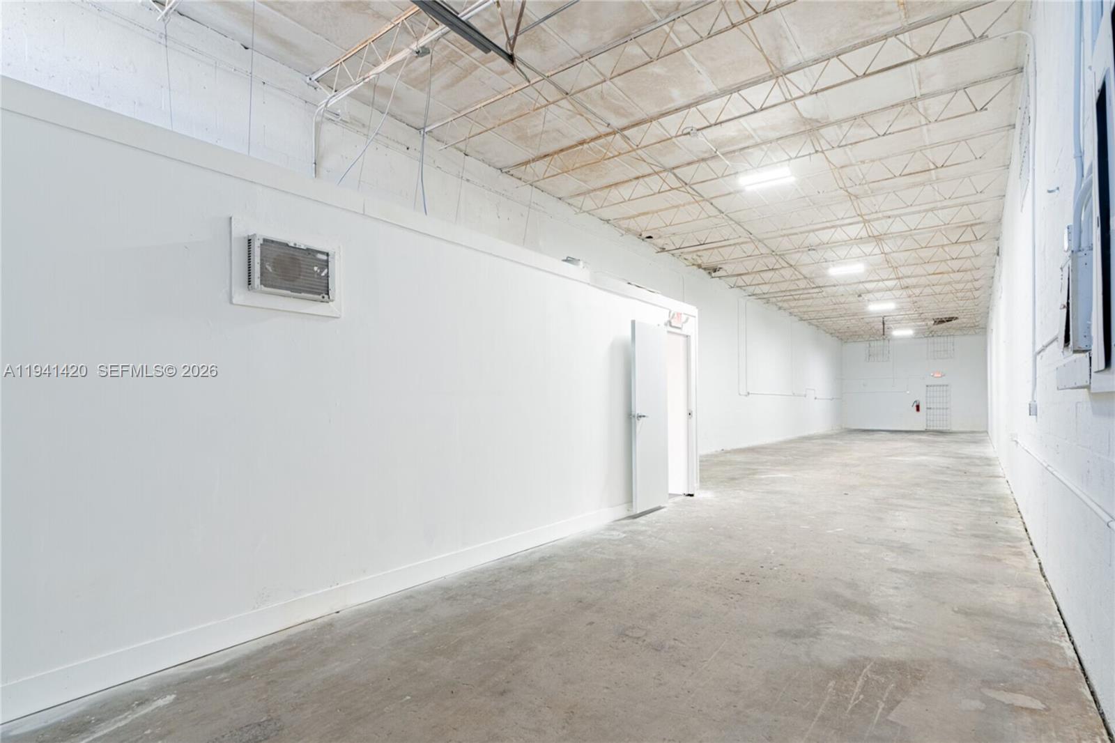 A long, empty industrial warehouse space features white walls, a concrete floor, and exposed ceiling trusses — 726 W 28th St, Hialeah FL 33010, HIALEAH, FL