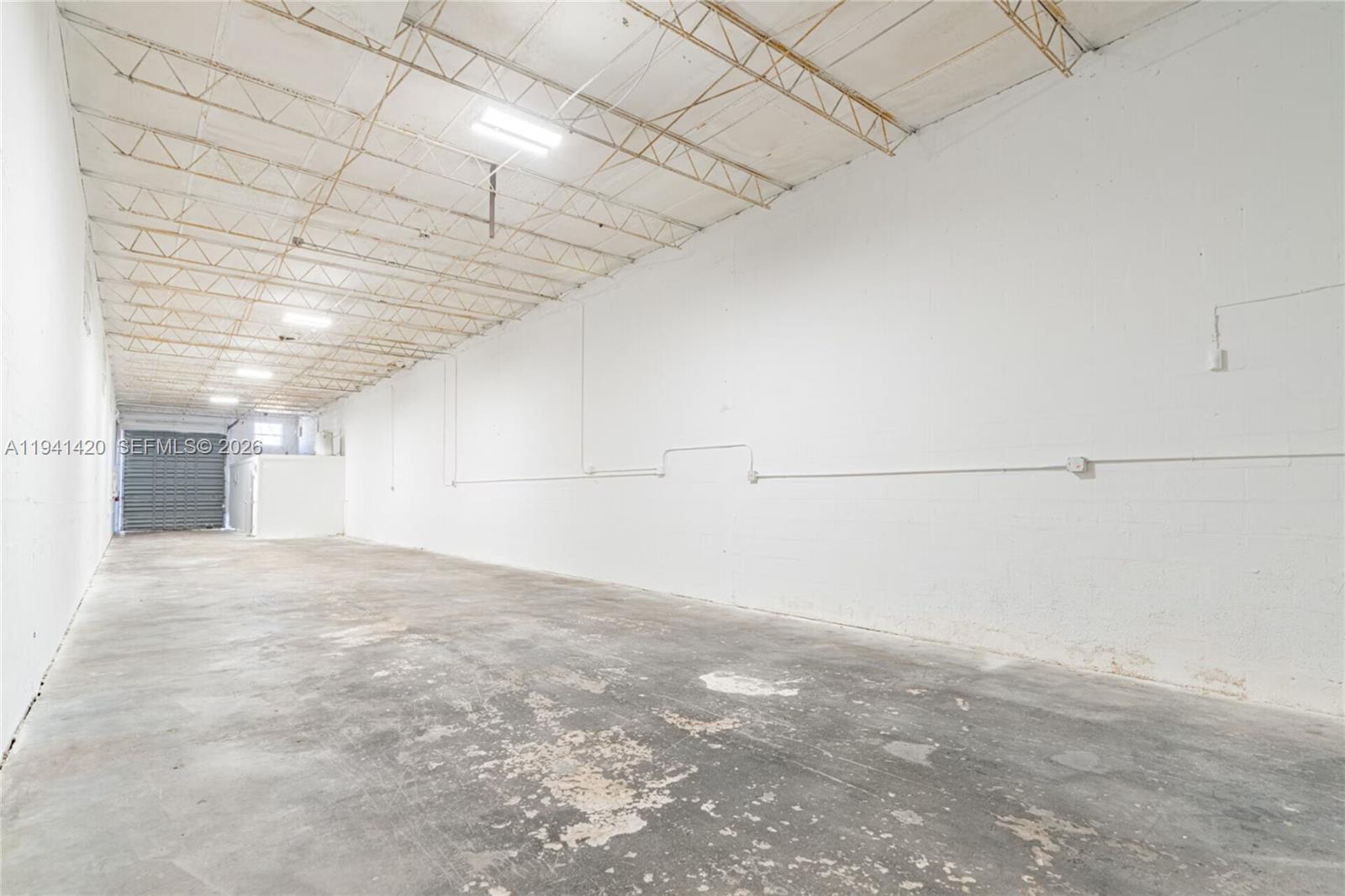 An empty industrial warehouse space features white concrete block walls and an exposed ceiling — 726 W 28th St, Hialeah FL 33010, HIALEAH, FL