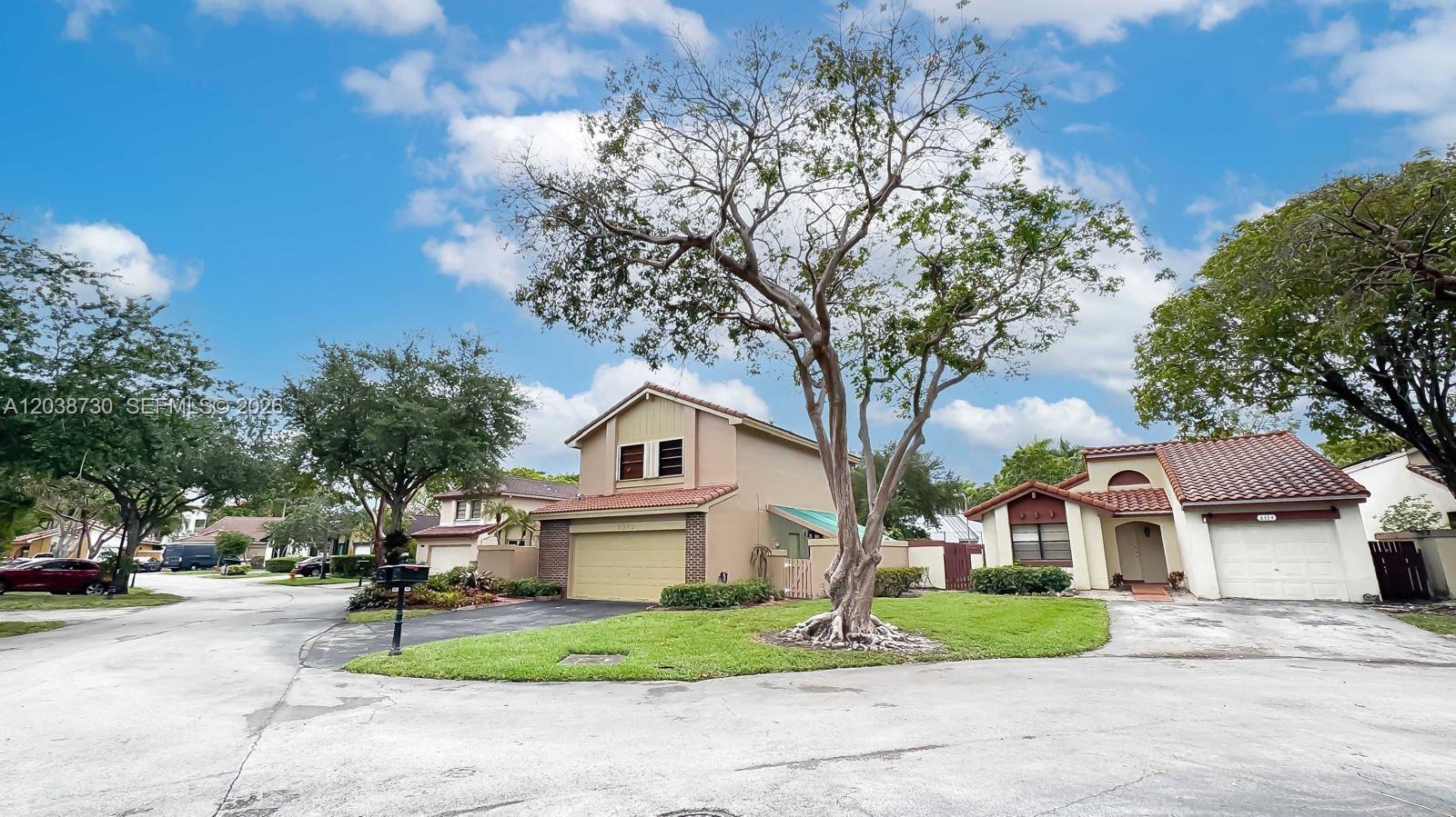 A two-story house with a tan exterior and a red tile roof sits on a corner — 6320 NW 173rd St, Hialeah FL 33015, HIALEAH, FL