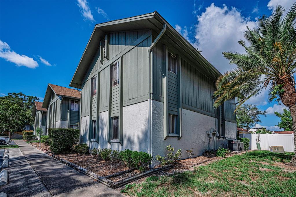 The exterior of a two-story multi-family building with green vertical siding and white stucco walls — 1960 UNION STREET UNIT 5, CLEARWATER, FL