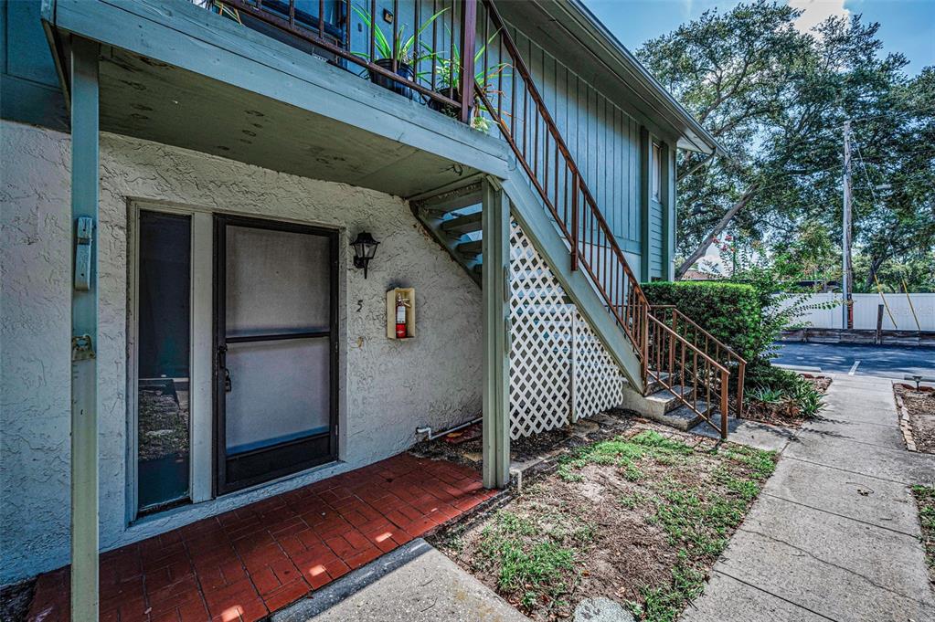 An exterior view shows a ground-level entrance with a brick porch and an outdoor staircase — 1960 UNION STREET UNIT 5, CLEARWATER, FL