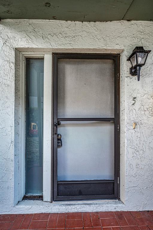 A front entrance featuring a screen door, a side window, and a wall-mounted light fixture — 1960 UNION STREET UNIT 5, CLEARWATER, FL