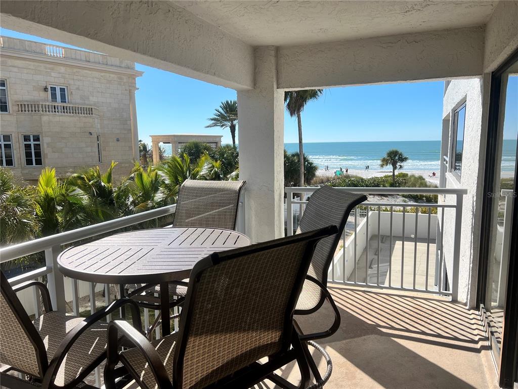 A balcony with a table and chairs overlooks a beach and the ocean — 1001 POINT OF ROCKS ROAD UNIT 309, SARASOTA, FL