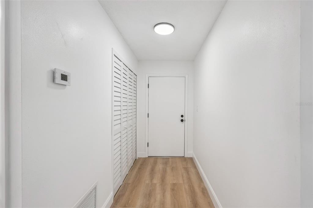 A hallway features white walls, light wood-look flooring, a closet with louvered doors, and a thermostat — 336 TANGERINE STREET, ALTAMONTE SPRINGS, FL