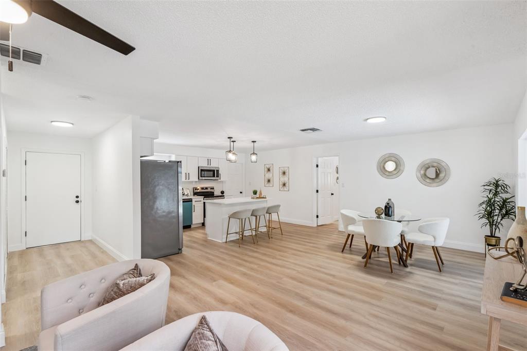 An open-concept kitchen and dining area features white cabinetry, a breakfast island, and light flooring — 336 TANGERINE STREET, ALTAMONTE SPRINGS, FL