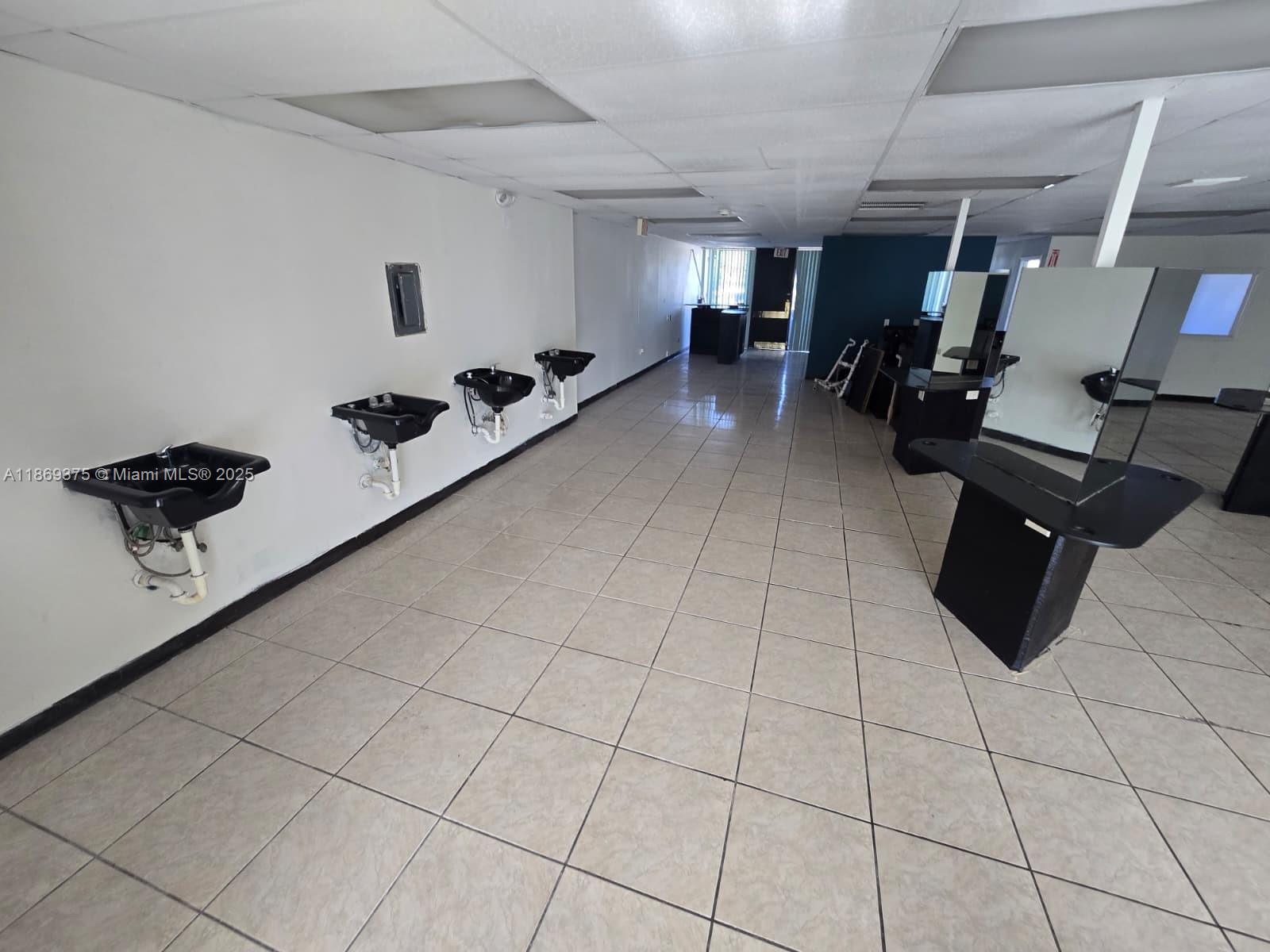 An interior view of a commercial space featuring wall-mounted sinks and salon styling stations — 2501 N State Road 7, Margate FL 33063, MARGATE, FL