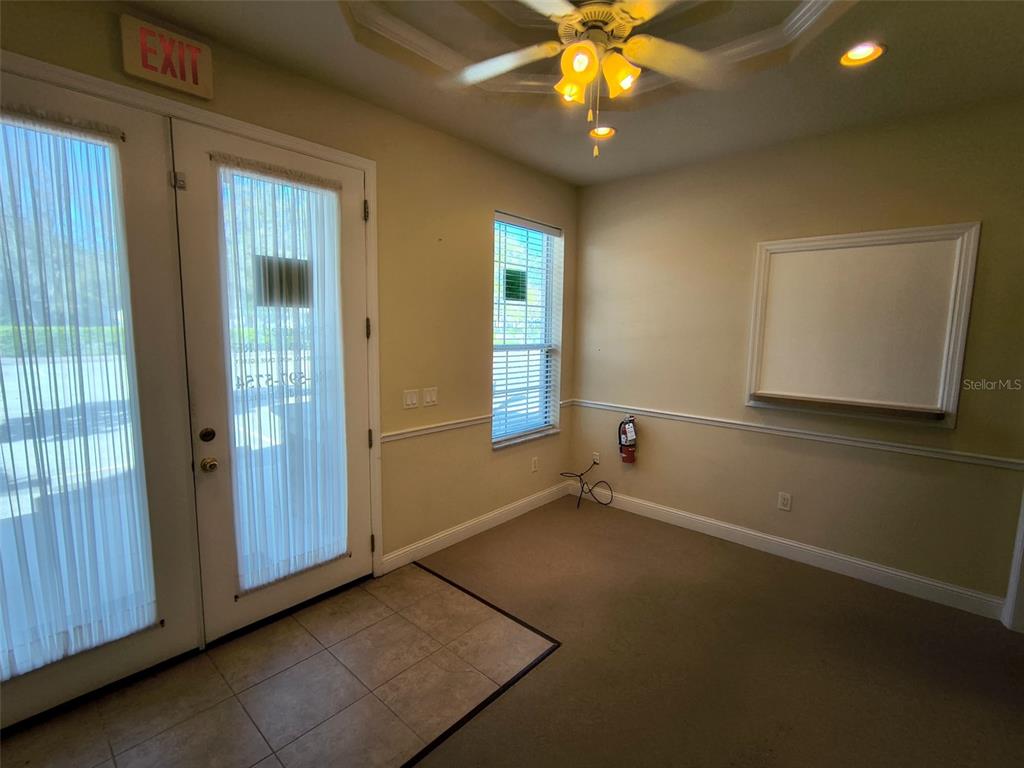 An office or meeting room features a glass door, carpeted floor, and a wall-mounted whiteboard — 4875 PALM COAST PARKWAY NW UNIT 4, PALM COAST, FL