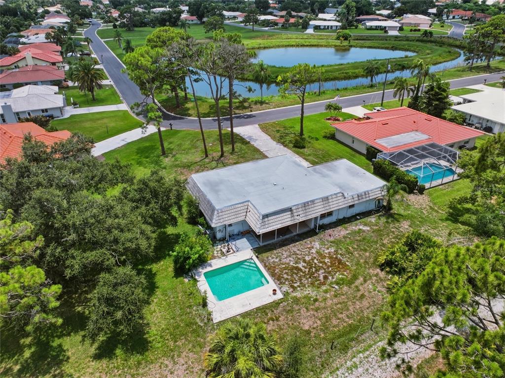 An aerial view shows a house with a pool, a large yard, and a nearby pond — 427 RUBENS DRIVE, NOKOMIS, FL