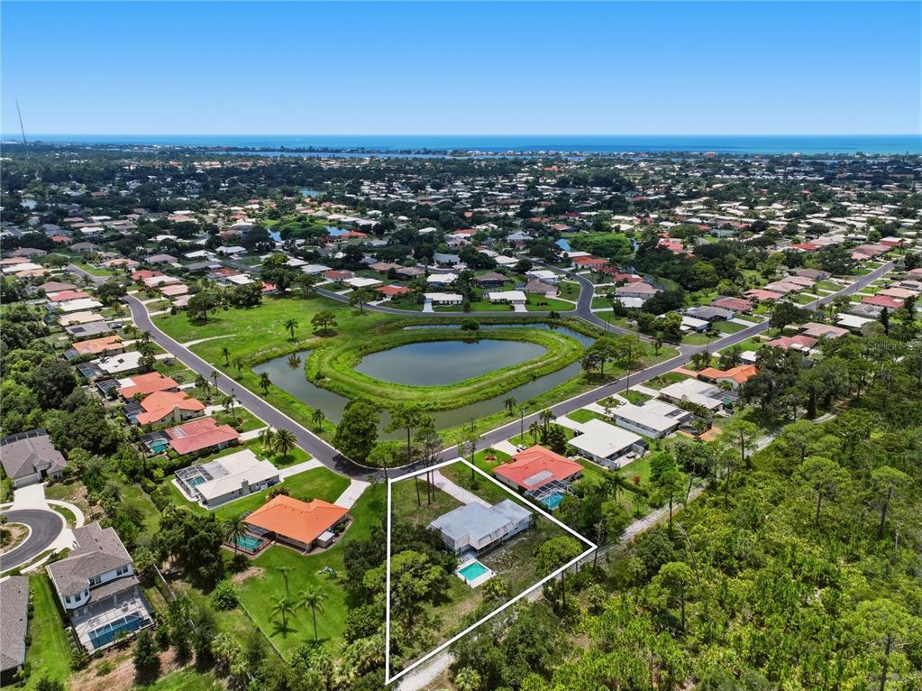 An aerial view shows a single-story house with a pool on a triangular lot — 427 RUBENS DRIVE, NOKOMIS, FL