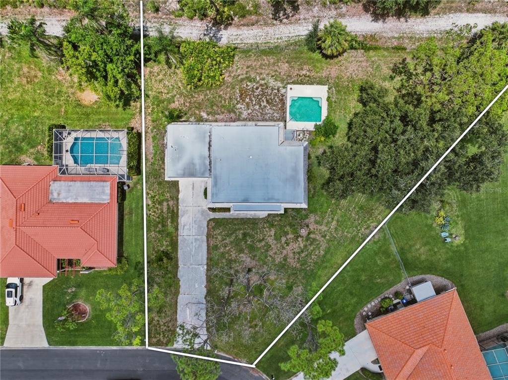 An aerial view shows a house with a flat roof, driveway, and backyard swimming pool — 427 RUBENS DRIVE, NOKOMIS, FL
