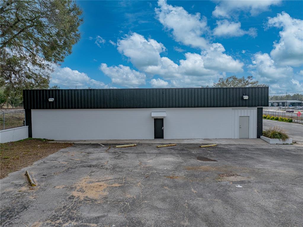 A single-story commercial building with a white brick facade and a black metal roofline — 15552 US HIGHWAY 301, DADE CITY, FL
