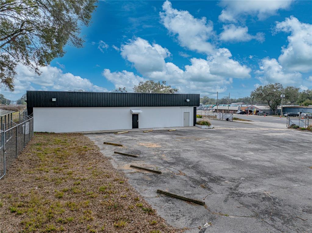 A white commercial building with a black roof and a paved parking lot — 15552 US HIGHWAY 301, DADE CITY, FL