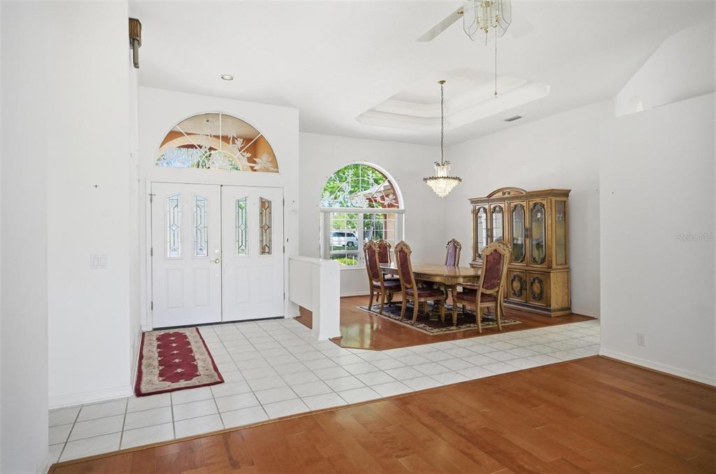 A dining room with a chandelier, wood floors, and a tile entryway near the front door — 22 FORDS WAY, PALM COAST, FL