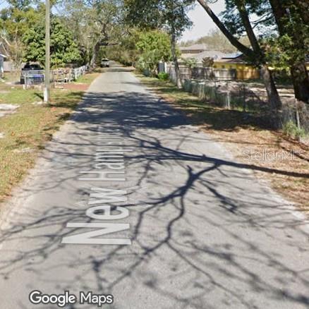 A paved residential street lined with trees and houses on a sunny day — 210 N NEW HAMPSHIRE AVENUE, APOPKA, FL