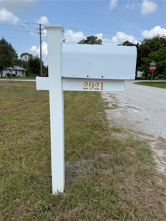 A white mailbox on a post stands in a grassy area near a paved road — 2921 GARRET STREET, DELTONA, FL