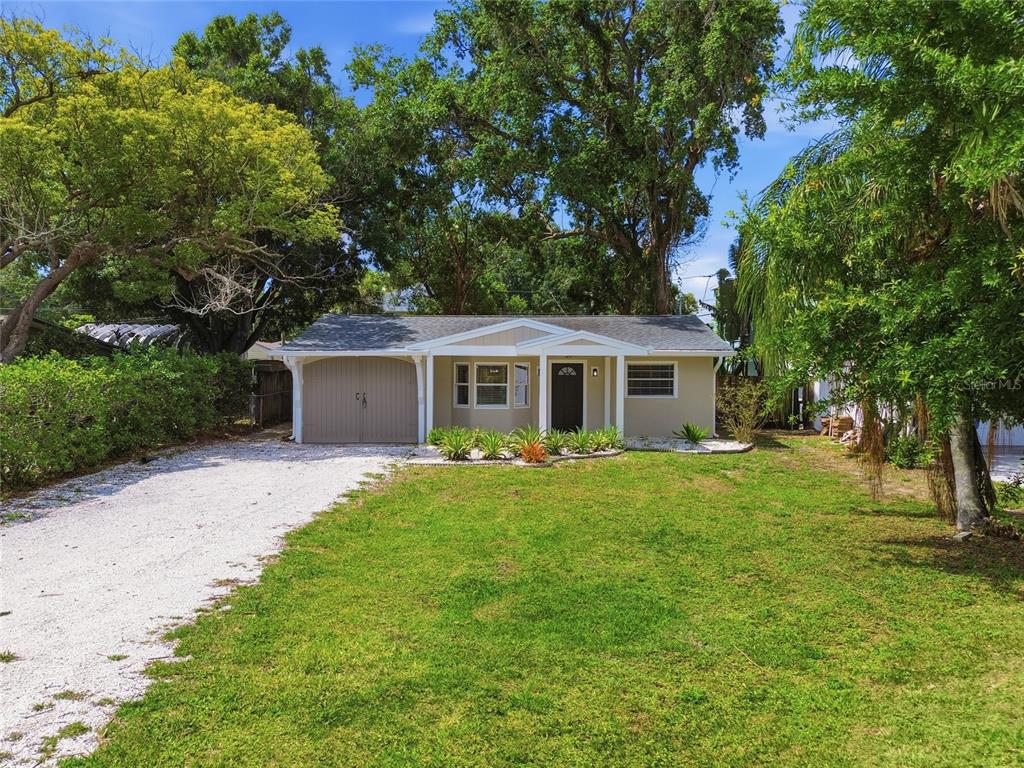 A single-story house with a gravel driveway, a one-car garage, and a front lawn — 125 CRYSTAL BEACH AVENUE, CRYSTAL BEACH, FL