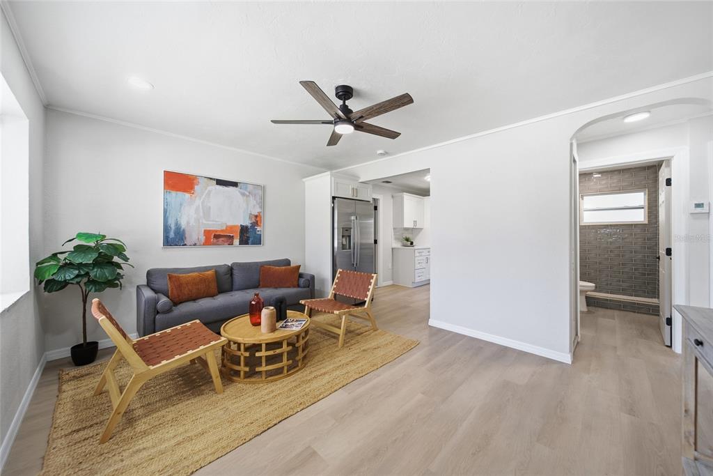 A living room features a gray sofa, two wooden chairs, a round table, and light flooring — 125 CRYSTAL BEACH AVENUE, CRYSTAL BEACH, FL