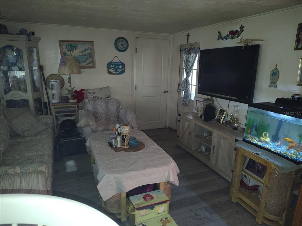 A living room features a television, a fish tank, a coffee table, and a sofa — 37748 MARKLAND AVENUE, ZEPHYRHILLS, FL
