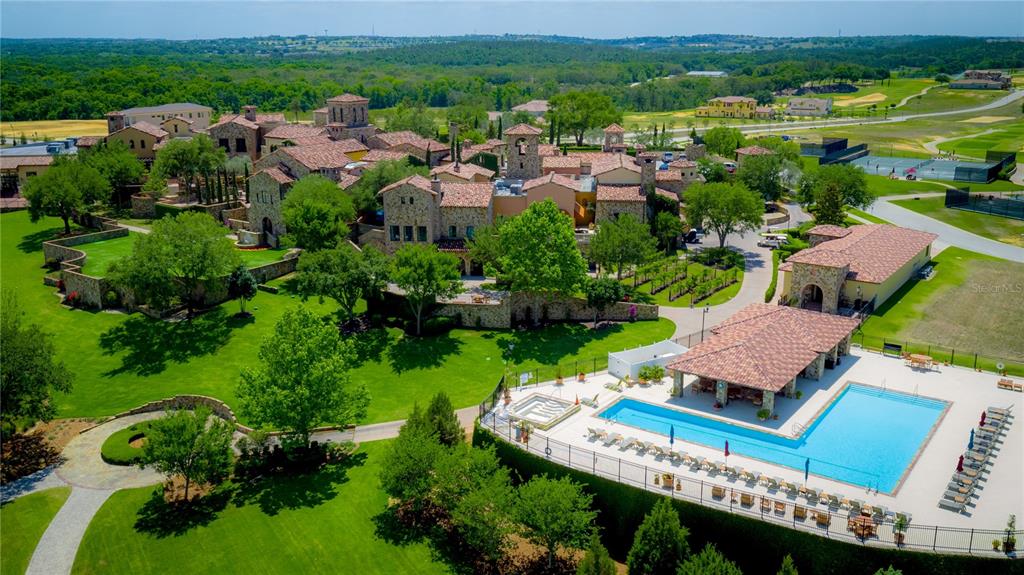 An aerial view shows a large stone estate with a pool, patio, and landscaped grounds — 16122 TRIVOLI CIRCLE, BELLA COLLINA, FL