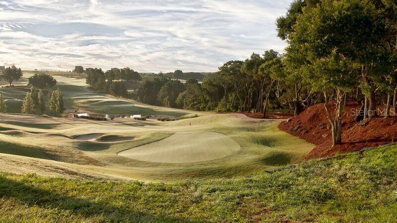 A view of a golf course fairway with a putting green, sand bunkers, and trees — 16122 TRIVOLI CIRCLE, BELLA COLLINA, FL