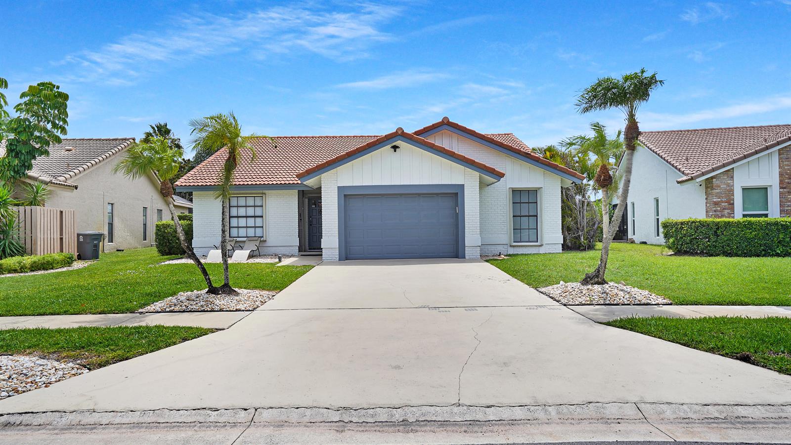 A single-story house with a white brick exterior, a gray garage door, and palm trees — 10131 Camelback Lane, Boca Raton FL 33498, BOCA RATON, FL