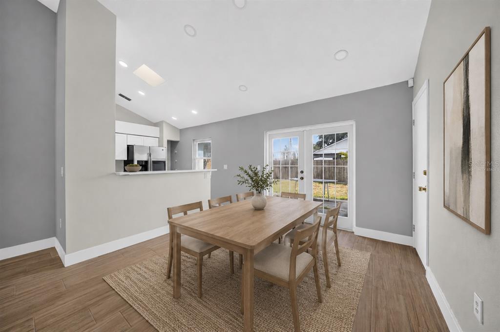 A dining room with a wooden table, chairs, rug, and a view of the kitchen — 2007 59TH CIRCLE S, ST PETERSBURG, FL