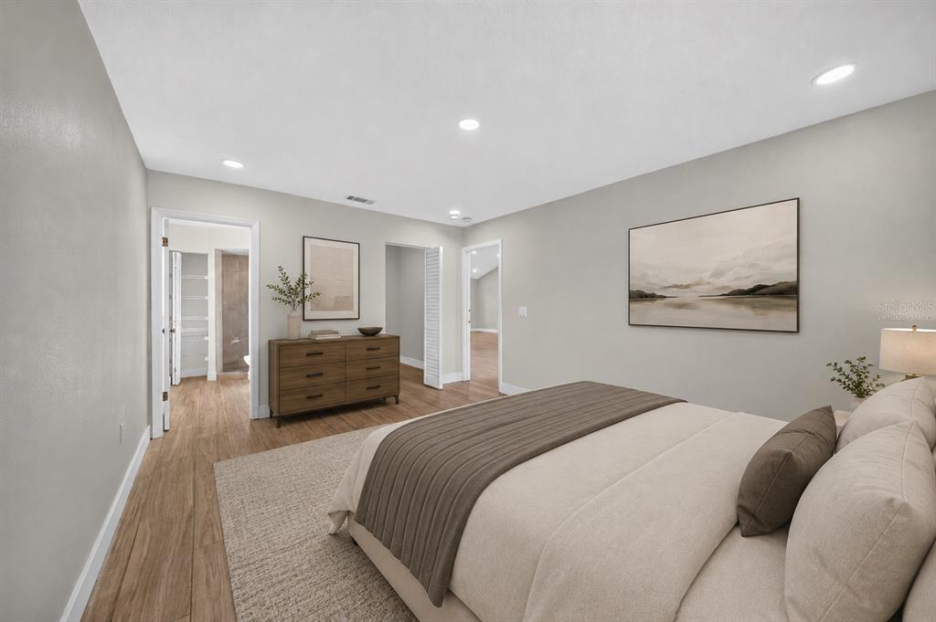 A bedroom with light gray walls, wood-look flooring, a bed, and a dresser — 2007 59TH CIRCLE S, ST PETERSBURG, FL