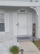A white front door with shutters and a house number sits above a concrete walkway — 4629 SABAL KEY DRIVE UNIT 4629, BRADENTON, FL