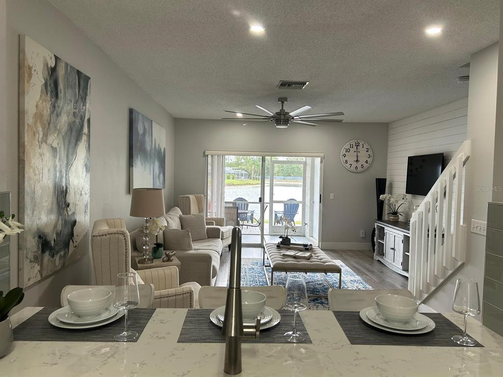A kitchen island overlooks a living room with a sofa, coffee table, and sliding glass doors — 4629 SABAL KEY DRIVE UNIT 4629, BRADENTON, FL
