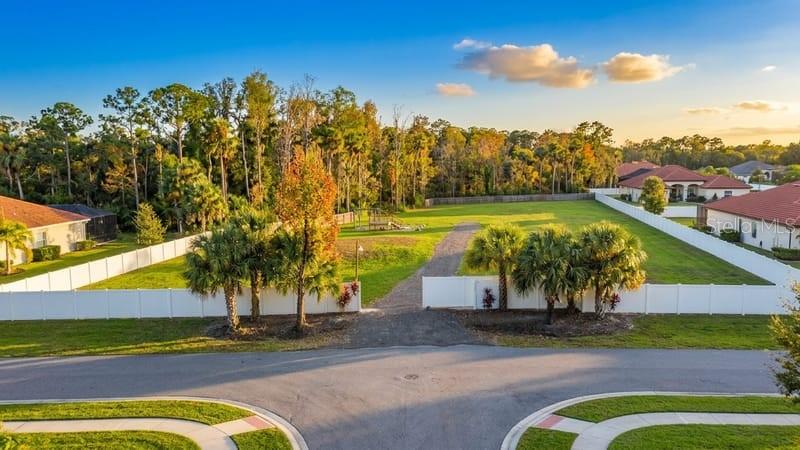 An aerial view of a fenced, vacant residential lot situated between two houses — 6518 OLD TAMPA HIGHWAY UNIT A, DAVENPORT, FL