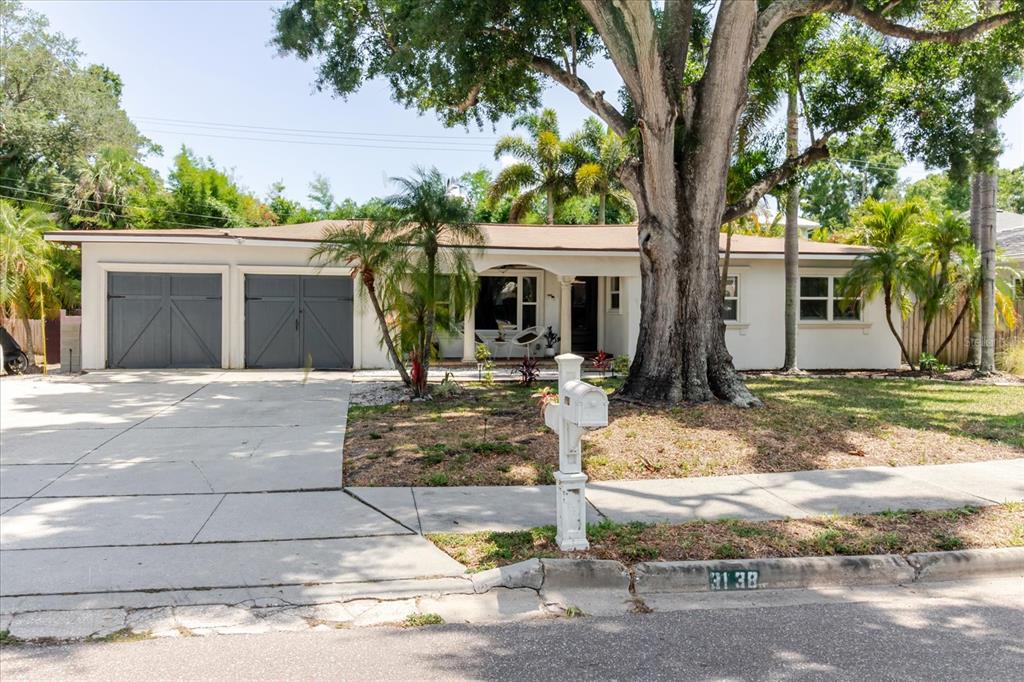 A single-story house with a two-car garage and a large tree in the front yard — 3138 W EUCLID AVENUE, TAMPA, FL