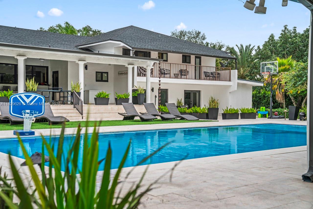 A two-story house with a swimming pool, basketball hoop, and lounge chairs on the patio — 14875 SW 212th St, Miami FL 33187, MIAMI, FL