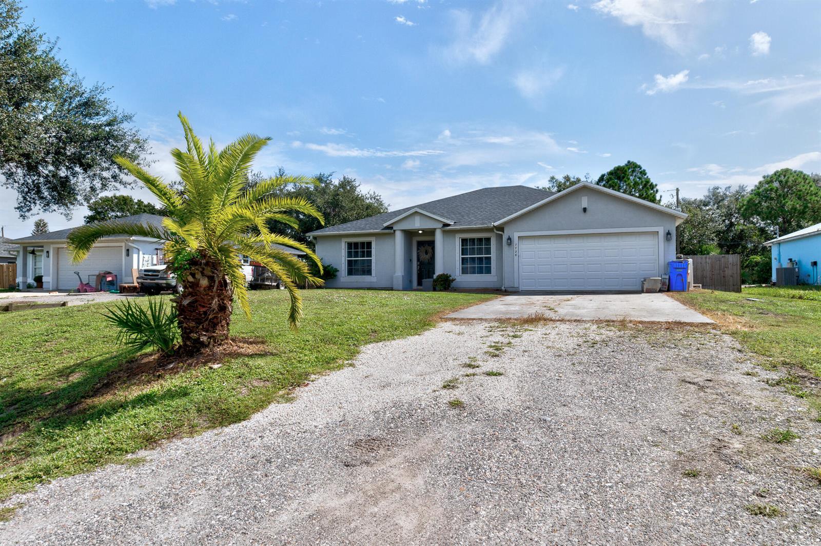 A single-story house with a gray exterior, a two-car garage, and a front porch — 7726 102nd Avenue, Vero Beach FL 32967, VERO BEACH, FL