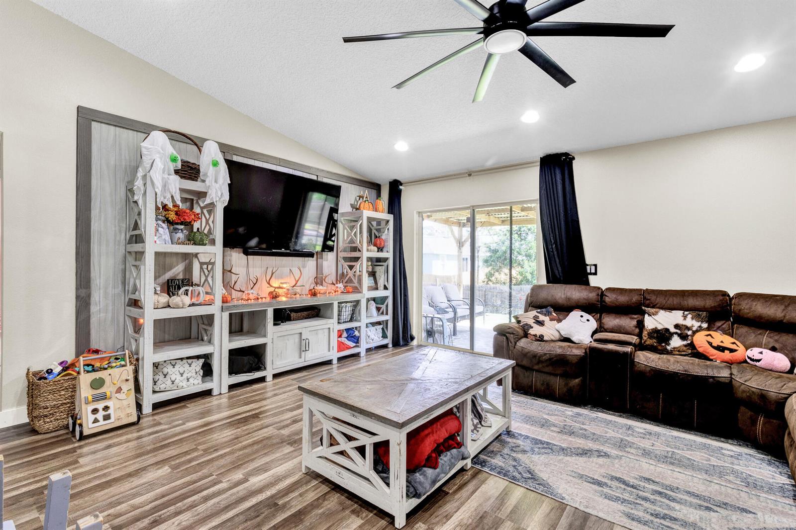 A living room features a brown sectional sofa, a television, and white farmhouse-style shelving — 7726 102nd Avenue, Vero Beach FL 32967, VERO BEACH, FL