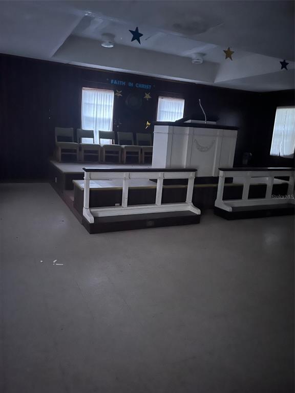 An interior view of a church sanctuary featuring a raised pulpit, altar, and wooden chairs — 1235 SAGE STREET, MONTICELLO, FL