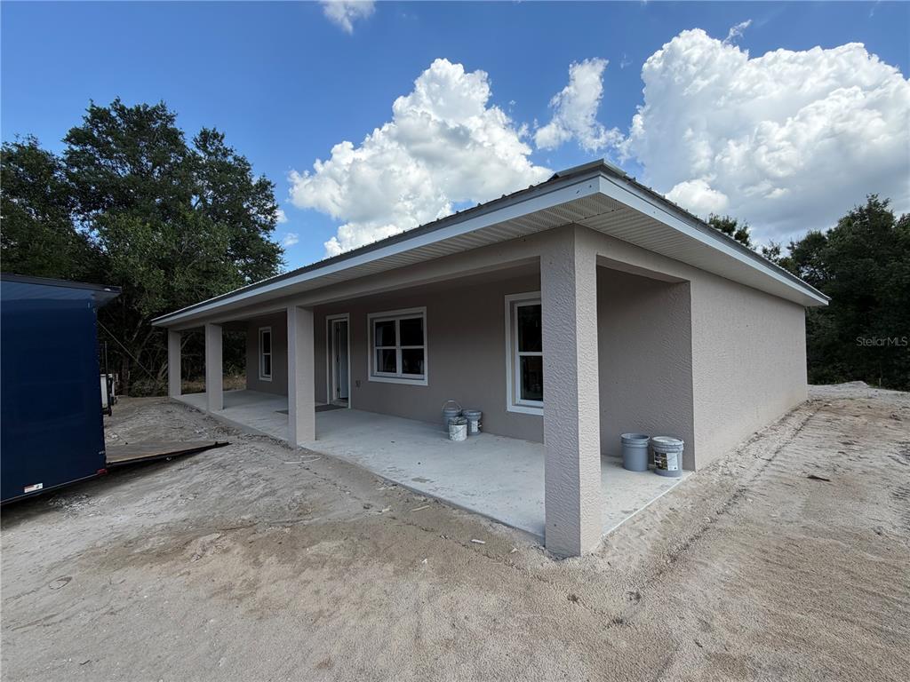 A single-story house exterior features a covered concrete porch with square support columns — 8115 SW EASY STREET, ARCADIA, FL