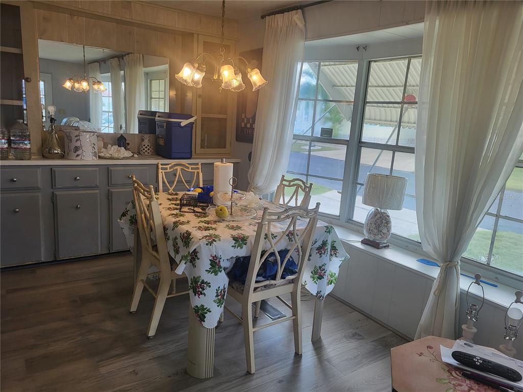 A dining area features a table with a floral tablecloth, four chairs, and a window — 357 BADGER LANE, HAINES CITY, FL