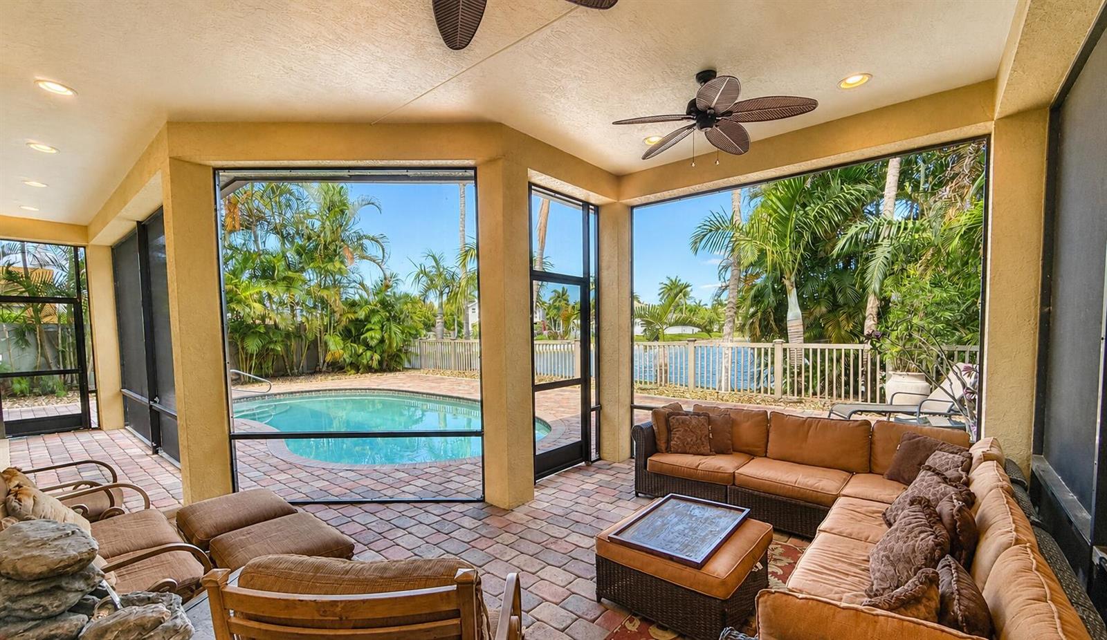 A screened-in patio features a brick floor, outdoor furniture, and a view of a pool — 3008 Hamblin Way, Wellington FL 33414, WELLINGTON, FL