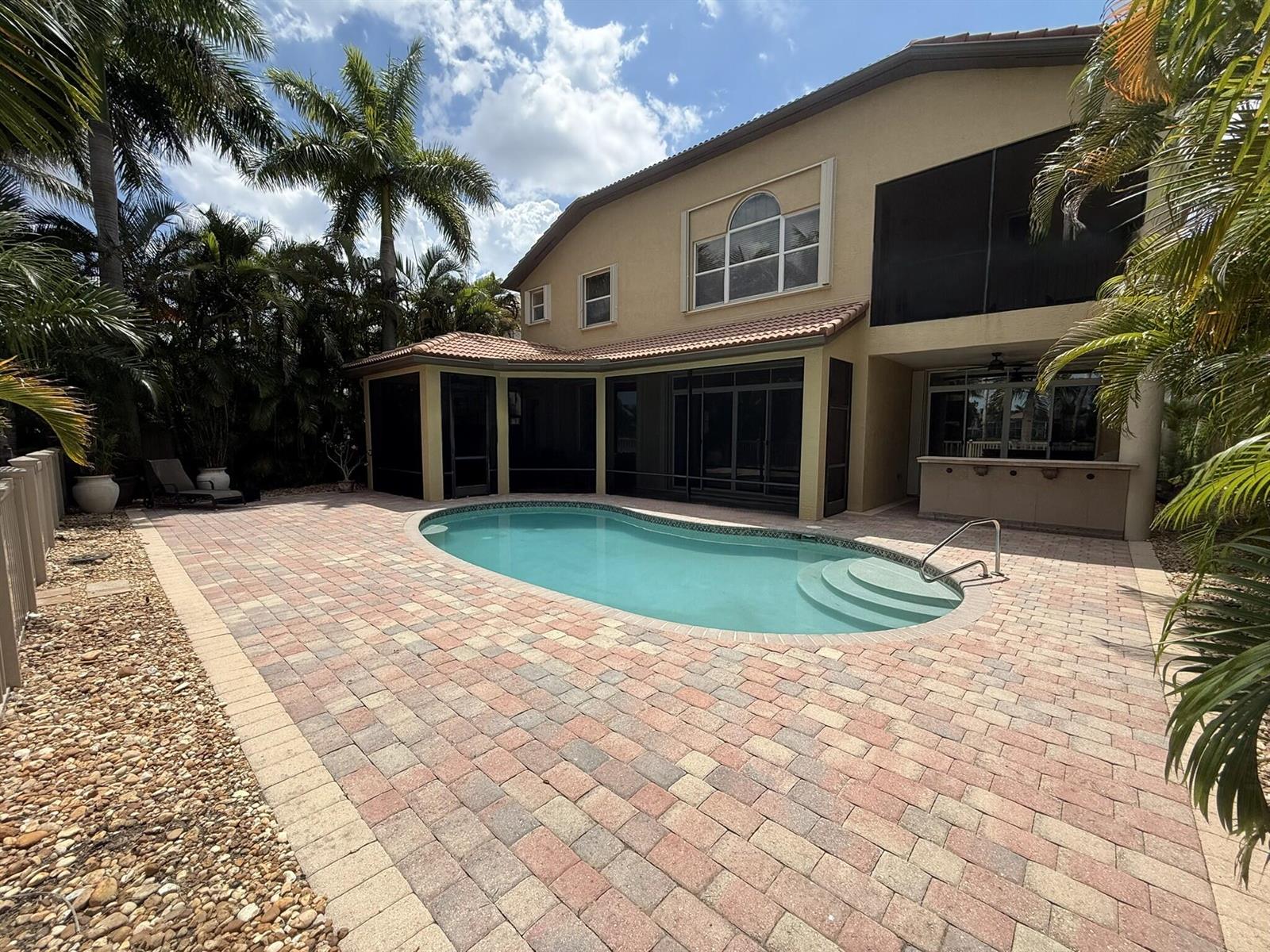 A two-story house with a screened-in patio, swimming pool, and paver deck in the backyard — 3008 Hamblin Way, Wellington FL 33414, WELLINGTON, FL