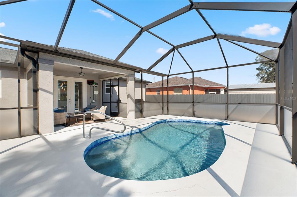A screened-in patio features a small swimming pool with a metal handrail and patio furniture — 4320 MICHALER STREET, NORTH PORT, FL