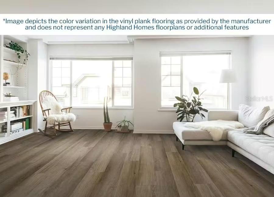 A bright living room features wood-look vinyl plank flooring, a white sofa, and large windows — 5990 FRESHWATER CANYON DRIVE, ST CLOUD, FL