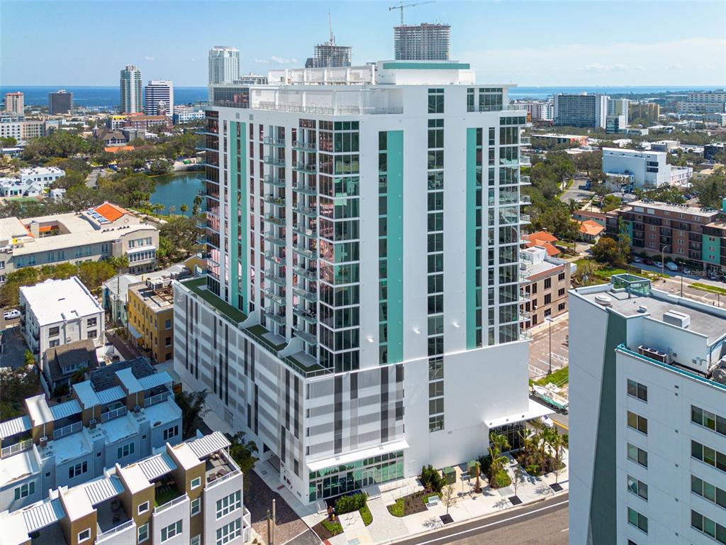An aerial view of a modern high-rise apartment building with a white and teal facade — 777 3RD AVENUE N UNIT 1104, ST PETERSBURG, FL