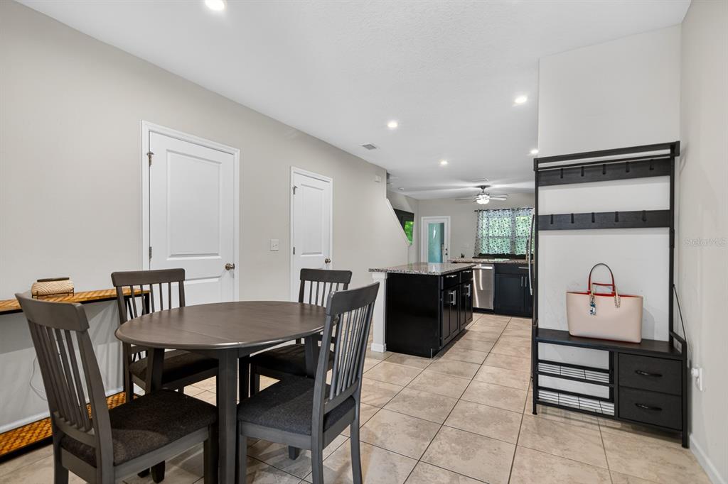 A dining area with a dark wood table and chairs sits adjacent to a kitchen — 3083 VICTORIA INLET DRIVE, HOLIDAY, FL