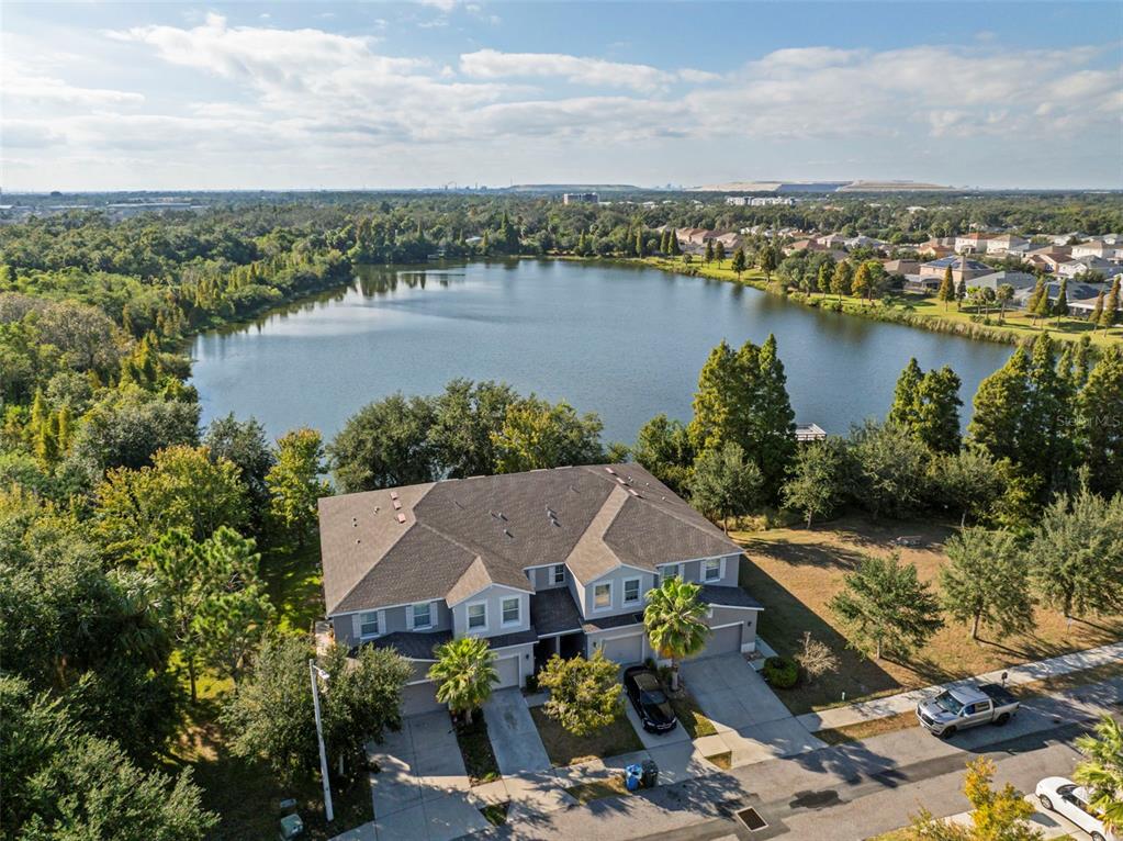 An aerial view shows a two-story duplex house situated next to a large lake — 10523 LAKE MONTAUK DRIVE, RIVERVIEW, FL
