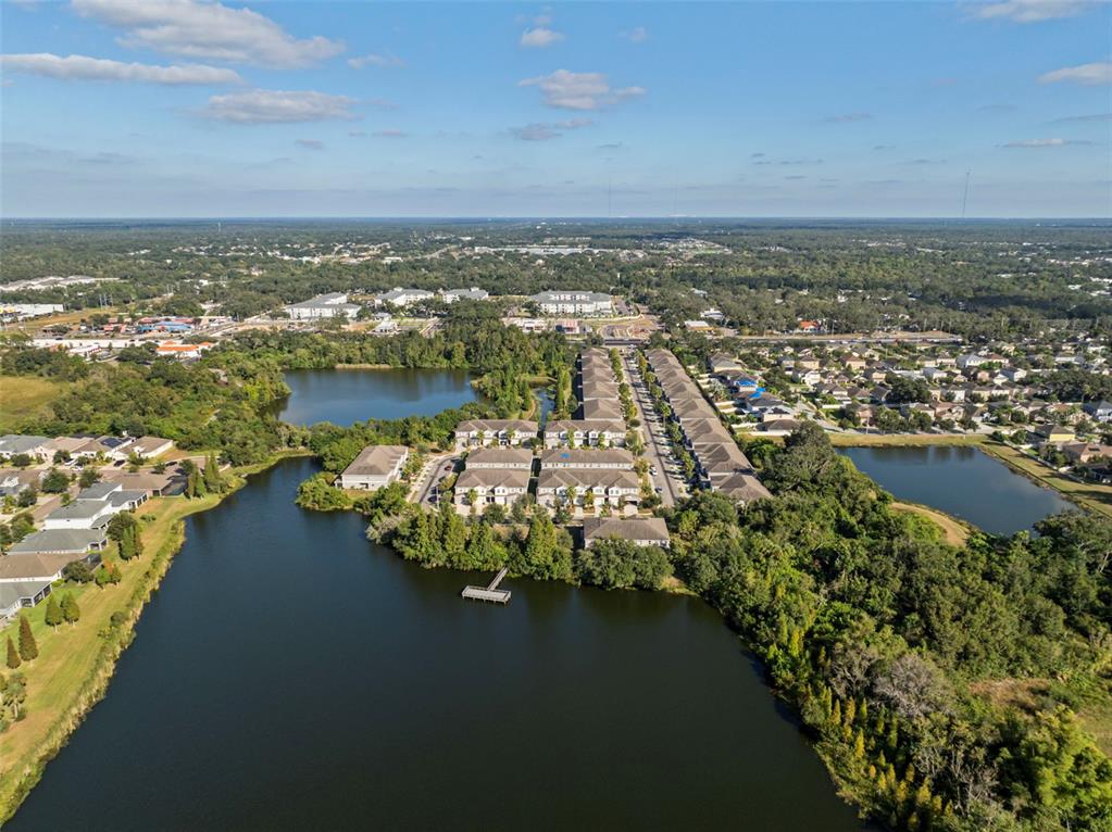 An aerial view shows a residential complex surrounded by lakes and dense green trees — 10523 LAKE MONTAUK DRIVE, RIVERVIEW, FL